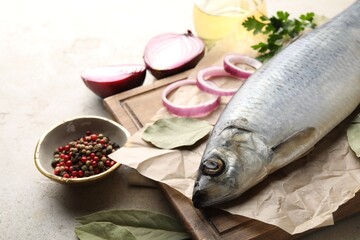Salted herring and spices on light grey table, closeup