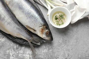 Salted herrings and spices on grey table, flat lay. Space for text