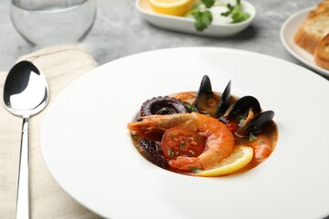 Delicious seafood soup served on gray table, closeup