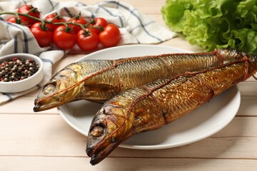 Delicious smoked herrings on white wooden table, closeup