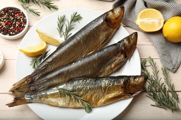 Smoked herrings and spices on wooden table, flat lay