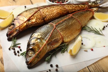 Smoked herrings and spices on wooden table, closeup