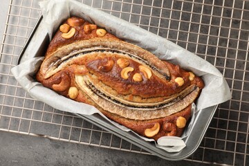 Delicious banana bread with nuts on grey table, top view