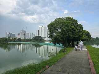 A scenic view of a paved pathway curving through a park.