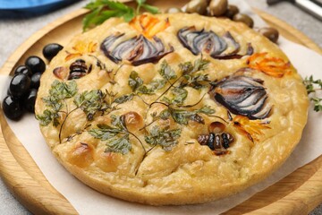 Delicious focaccia with flowers made of vegetables on table, closeup