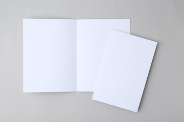 Blank greeting cards on light background, top view