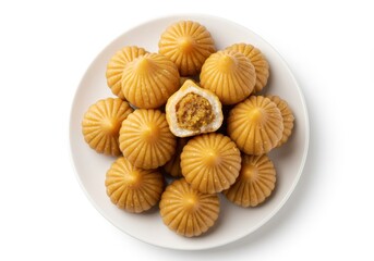 Modak dessert on a white plate with one cut open to show the filling