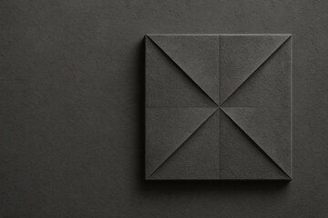 Dark textured wall panel with geometric design and folded corners in modern interior space