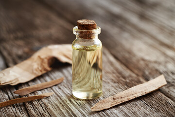 Essential oil bottle with pieces of white sandalwood