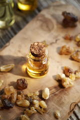 A bottle of frankincense essential oil with frankincense resin crystals