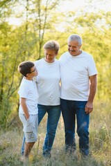 Fototapeta premium Grandfather grandmother and grandson having fun outdoors in park