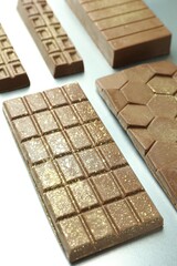 Different tasty Dubai chocolate bars with pistachios and knafeh on grey table