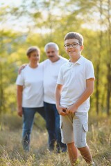 Fototapeta premium Grandfather grandmother and grandson having fun outdoors in park