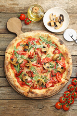 Tasty pizza with mushrooms, tomatoes, arugula and cutter on wooden table, flat lay