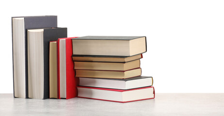 Old books on light grey table against white background