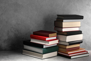 Stacks of old books on light grey table