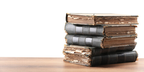 Old books on wooden table against white background
