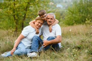 Grandfather grandmother and grandson having fun outdoors in park