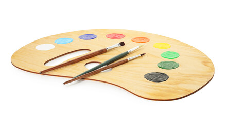 Wooden palette with paints and brushes isolated on white