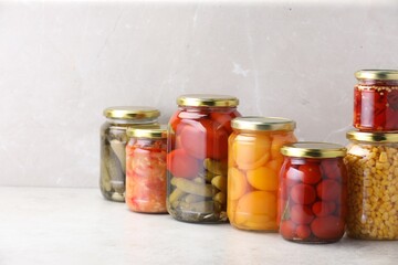 Many jars with different pickled products on light table. Space for text