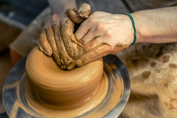 Close-up of male potter's hands making a vase. Pottery. Making ceramics.