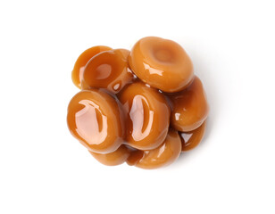 Tasty sweet candies and caramel sauce isolated on white, top view