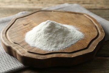 Pile of wheat flour on wooden table, closeup