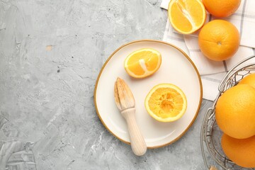 Wooden juicer and fresh oranges on grey table, flat lay. Space for text