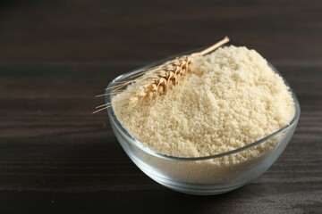 Flour and spike in bowl on dark wooden table, closeup