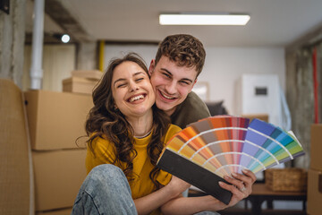 Portrait of couple hold color palette and choose new wall color