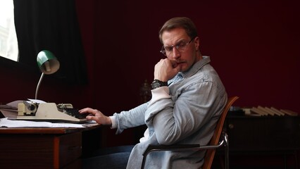 Male novelist deep in creative thought, vintage office with typewriter and papers in cinematic soft...