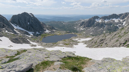 Mountain lake nestled in rocky terrain, snow patches visible, panoramic valley view; ideal for travel brochures