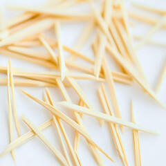 Scattered toothpicks on white background, close-up shot, suitable for dental or hygiene contexts