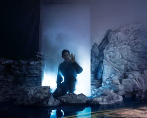 A man in overalls, an explorer in an ice cube with smoke, landing on another planet or being in a...