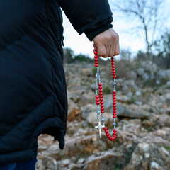 A pilgrim praying the rosary while climbing Mount Podbrdo in Medjugorje, Bosnia and Herzegovina.