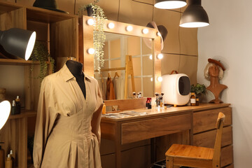 Interior of makeup room with table, mannequin and glowing lamps at night