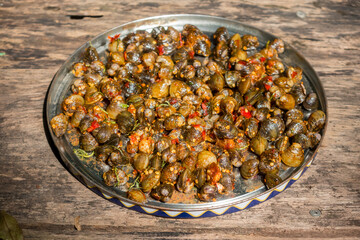 Close up of Thai style Stir Fried Clams with spicy Roasted Chili Paste on a large dish wood background.