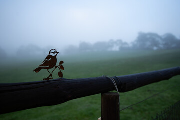 metal art in the shape of a bird on a fence