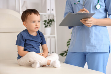 Cute little boy on couch visiting pediatrician in clinic