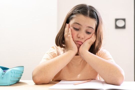 Young Student Appears Stressed Over Homework at a Desk