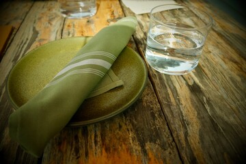 Green Napkin and plate with water glass on a restaurant table