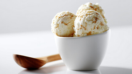 Three scoops of ice cream in a white cup with a wooden spoon near it isolated on white background