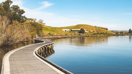 Obraz premium Boardwalk along the lake waihola new zealand beautiful landscape scenery wooden bridge 