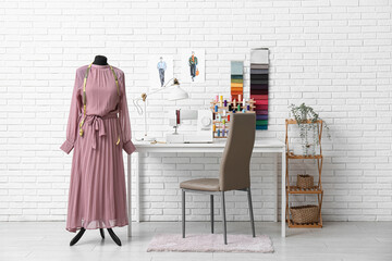 Interior of atelier with tailor's workplace, drawings and mannequin