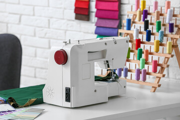 Sewing machine on tailor's table in atelier, closeup