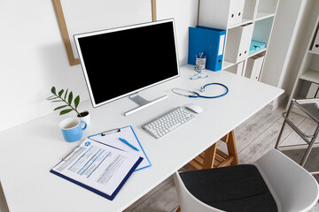 Doctor's workplace with blank computer monitor in medical office