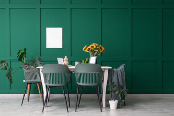 Interior of room with dining table, sunflowers in vase and plants