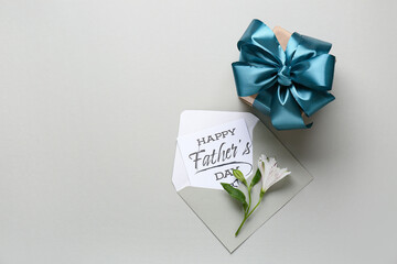 Postcard with gift box and flowers for Father's Day on white background