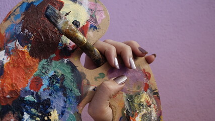 mano con pincel y paleta de colores y pintura