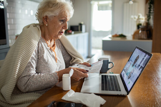 Senior woman doing online doctor consultation with medicine and laptop at home